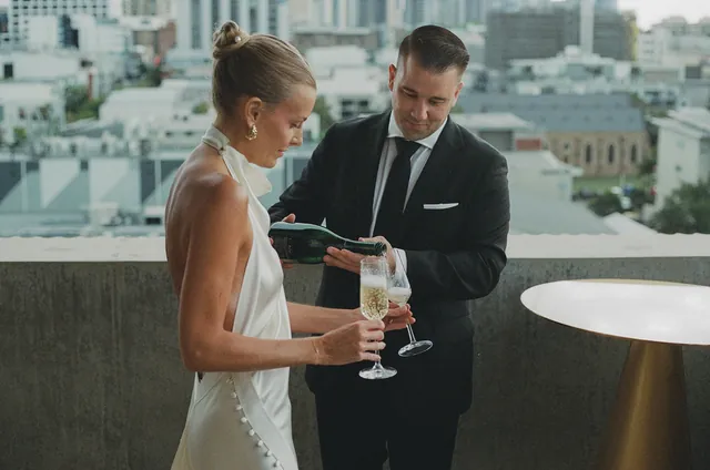 Matt reading his private vows from a green booklet beside Clare on the terrace.